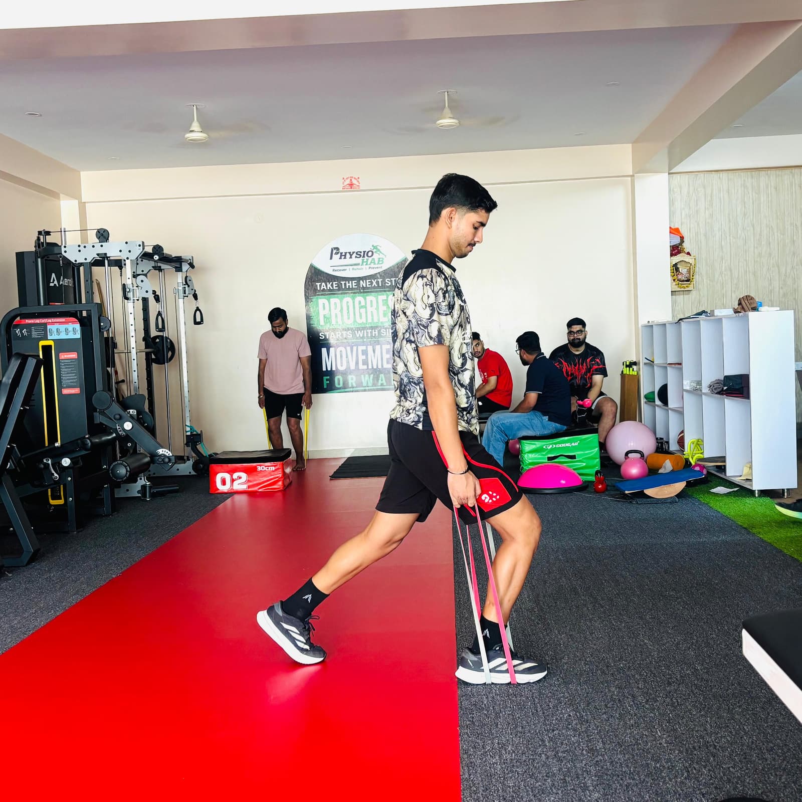 Patient performing a resisted lateral lunge with a resistance band on the clinic floor