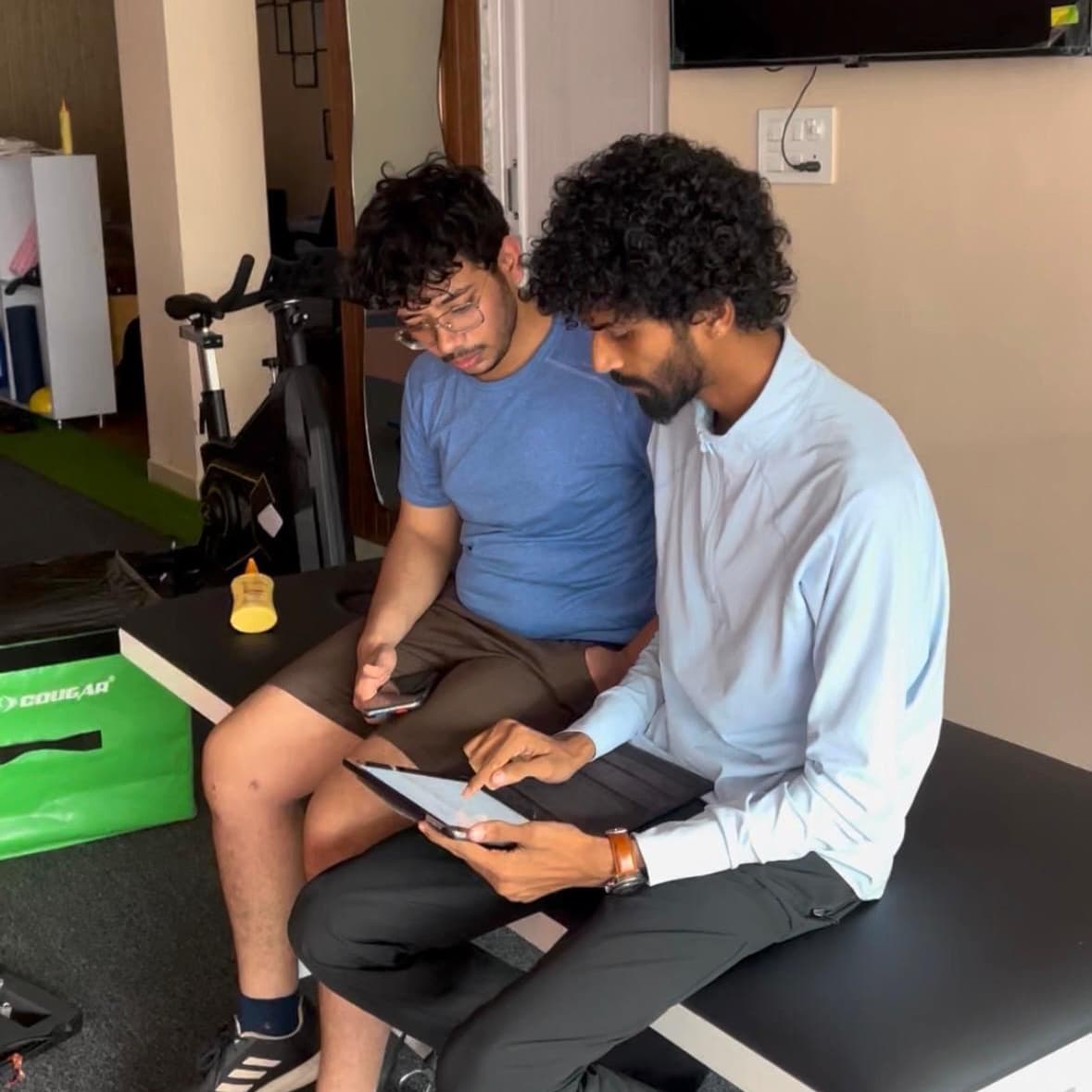 ACL PhysioHab physiotherapist reviewing a patient's rehab progress on a tablet during a consultation