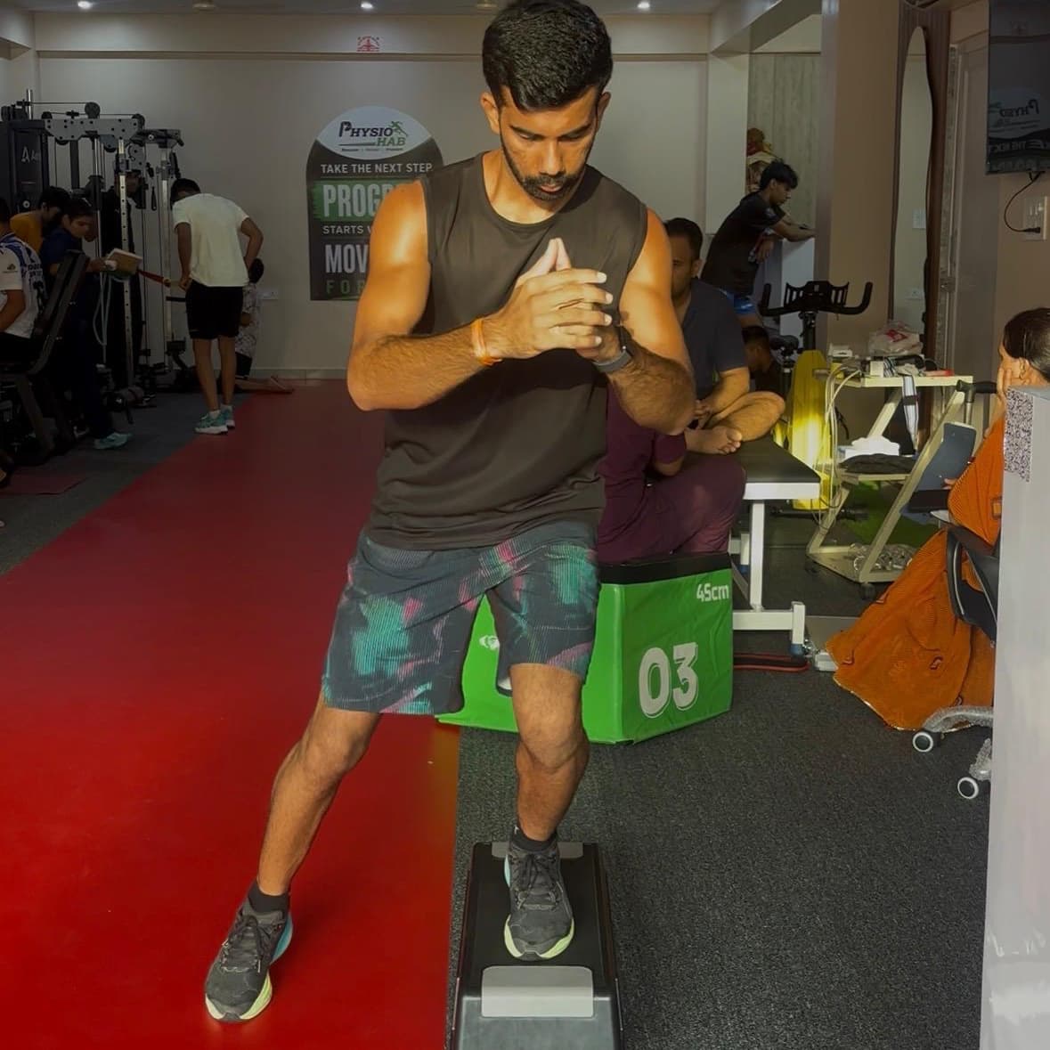 Patient performing a single-leg step-down balance drill on an aerobic step